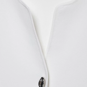 Minimalist white ribbed knit top featuring a deep V-neck and decorative silver metal button