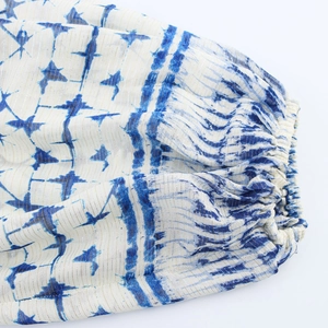 Close-up of elasticated cuffs with blue geometric tie-dye pattern and gold lurex threads