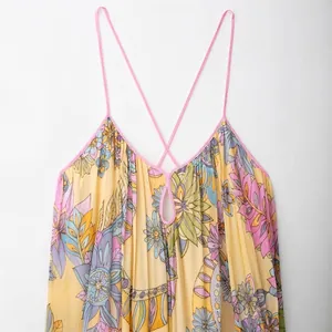 Floral print bohemian maxi dress in bright yellow with pink cross straps and hollow neck