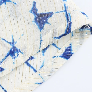Detail of V-neck dress with blue tie-dye print, gold lurex threads and fine stitching