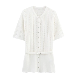 Close-up of white pointelle knit texture and ribbed hem detail on women's cardigan
