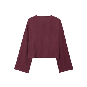 Close-up of dark burgundy long-sleeved top with textured crinkle fabric and drop shoulder
