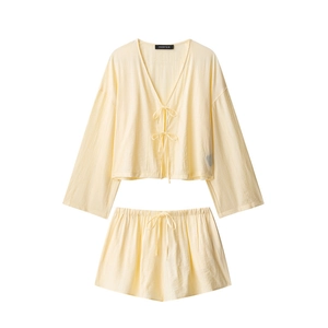 Detail of light yellow crinkle textured loungewear set with bow ties and elastic shorts