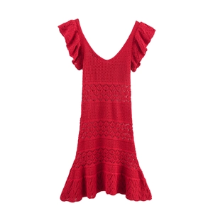 Detailed macro view of the red V-neck knit dress featuring ruffle sleeves and crochet pattern