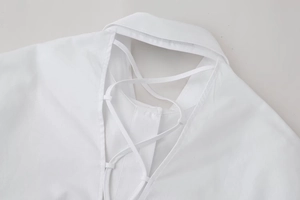Detail of white shirt showing back V-cutout with criss-cross lace-up ties and collar