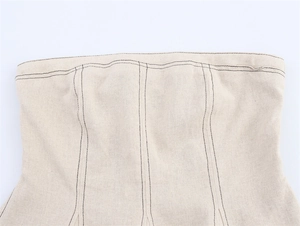 Détail d'un haut bustier en lin avec coutures contrastées sombres et texture du tissu