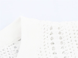 Detailed close-up of white mesh knit neckline with intricate geometric crochet texture