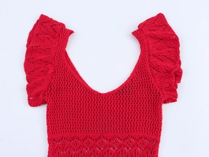 Detail of red V-neck knit top showing intricate hollow crochet texture and ruffle sleeves