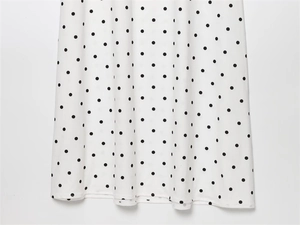 Detail of white French vintage dress with black polka dots and high-quality hem stitching