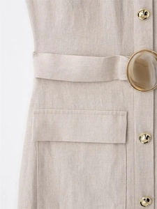 Detail des Leinen-Midikleids mit Bernsteinschnalle-Gürtel und Goldknöpfen an Tasche
