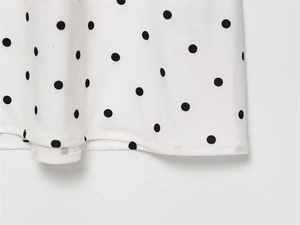 Detailed view of the French retro polka dot print and fine hem stitching on the white fabric