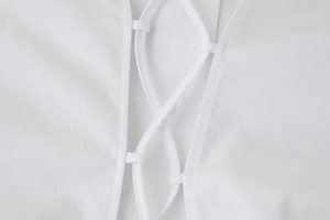 Detailed close-up of the white back lace-up design and cotton fabric on a cropped shirt
