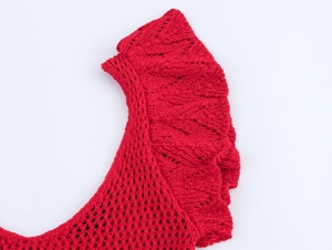Macro detail of red mesh knit fabric featuring ruffled wavy edge and textured weave