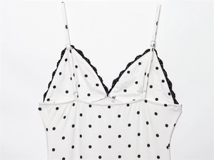 Detail of V-neck lace trim and black polka dots on summer dress fabric