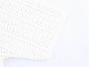 Detail of white crochet knit top showing intricate mesh texture and hollow-out patterns