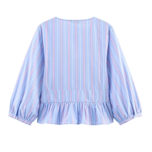 Detail view of the ruffle hem and striped pattern on the back of light blue women shirt
