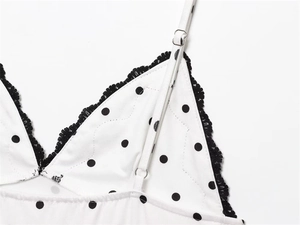 Close-up of polka dot fabric with black lace trim and adjustable shoulder straps