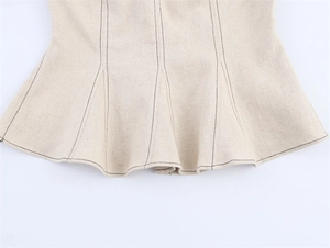 Gros plan des coutures contrastées sur le haut bustier en lin avec un ourlet péplum