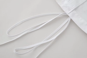 Detailed macro view of white shirt with button placket and stylish tie-up drawstring design