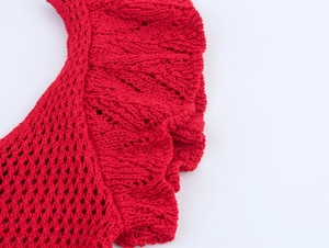 Close-up of red knit V-neck ruffle edge detail with delicate hollow weave pattern