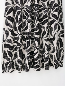 Detail of linen blend maxi dress showing black floral print and hemline stitching