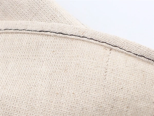 Vue macro du tissu en lin beige avec des détails de surpiqûres noires contrastées