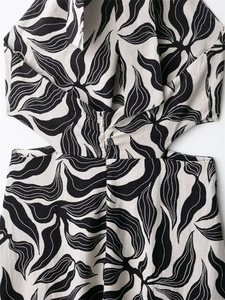 Macro detail of black leaf print linen dress showing waist cut-out and hidden zipper