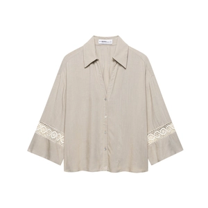 Detail of light khaki button-up shirt featuring white lace stitching and pearl buttons