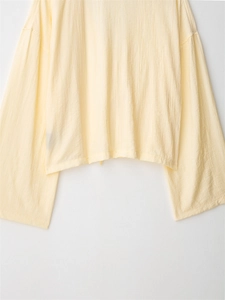 Detail shot of the cream-yellow long-sleeved shirt showing the crinkle fabric texture