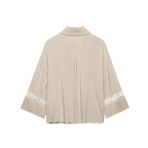 Detail of beige long-sleeve shirt with white lace hollow-out embroidery on the sleeves