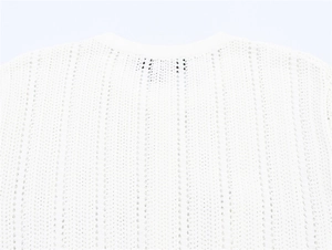 Detail shot of white mesh knit top featuring vertical hollow patterns and round neckline