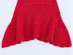 Detailed macro view of the scalloped hem and intricate hollow knit texture in bright red