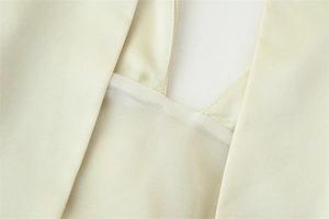 Close-up of the V-neckline with sheer insert on a light beige halter dress