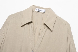 Detail of minimalist beige shirt neckline with textured fabric and BBWM label