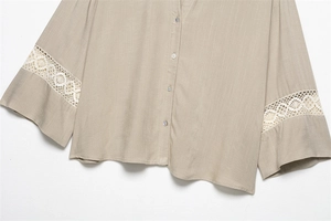 Detail of V-neck beige shirt featuring delicate lace stitching on flared sleeves