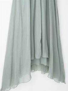 Detailed macro view of the layered pleated chiffon hem and inner lining of the maxi dress