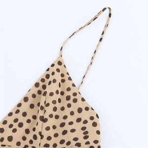 Détail des fines bretelles d'une robe élégante beige à pois avec des coutures de haute qualité