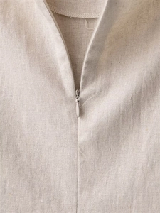 Makrodetail eines hochwertigen verdeckten Reißverschlusses an einem beigen Leinenkleid
