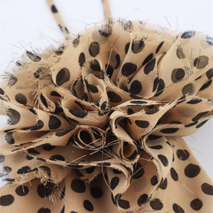 Vue détaillée de l'accessoire fleur en tissu à pois kaki avec bords effilochés