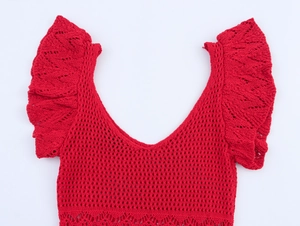Detail of red hollow knit dress featuring ruffled V-neck and scalloped lace hemline