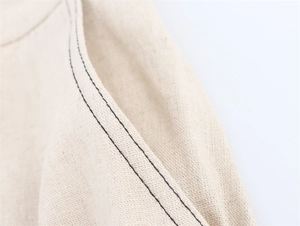Détail des surpiqûres contrastées et du lin sur un ensemble bustier couleur crème