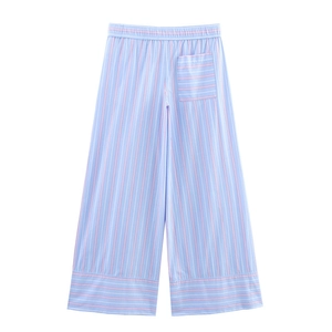 Detail of light blue striped wide-leg pants featuring elastic waist and cotton fabric texture