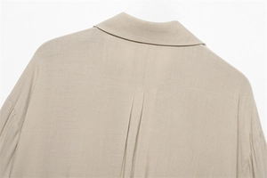 Detail of khaki linen blouse showing back pleat and classic collar texture
