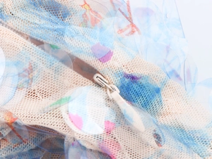 Macro shot of iridescent sequins and invisible zipper on mesh fabric dress