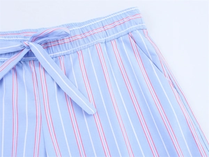 Detail of blue striped shorts featuring a drawstring elastic waist and side pockets