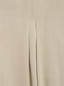 Detailed view of the box pleat texture on oatmeal linen trousers with premium stitching