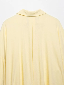 Detail view of the back pleat and classic collar on a pale yellow linen blend shirt