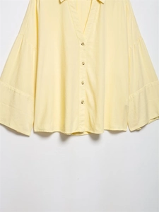 Detail of linen blend shirt showing V-neckline, texture and flared sleeves