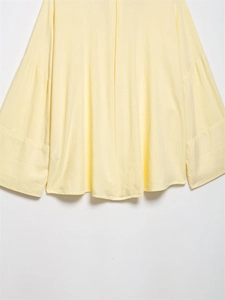 Close-up of light yellow linen blend shirt fabric texture and stitching details