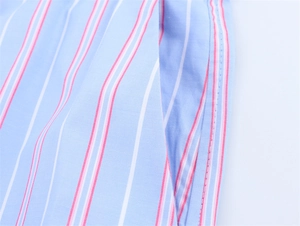 Macro detail of side pocket and pink stripes on blue cotton blend fabric with stitching